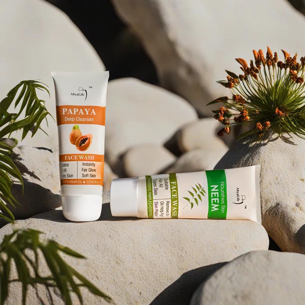 Two AbyaLife face wash products, Papaya and Neem, stand side-by-side on a rock with text above.